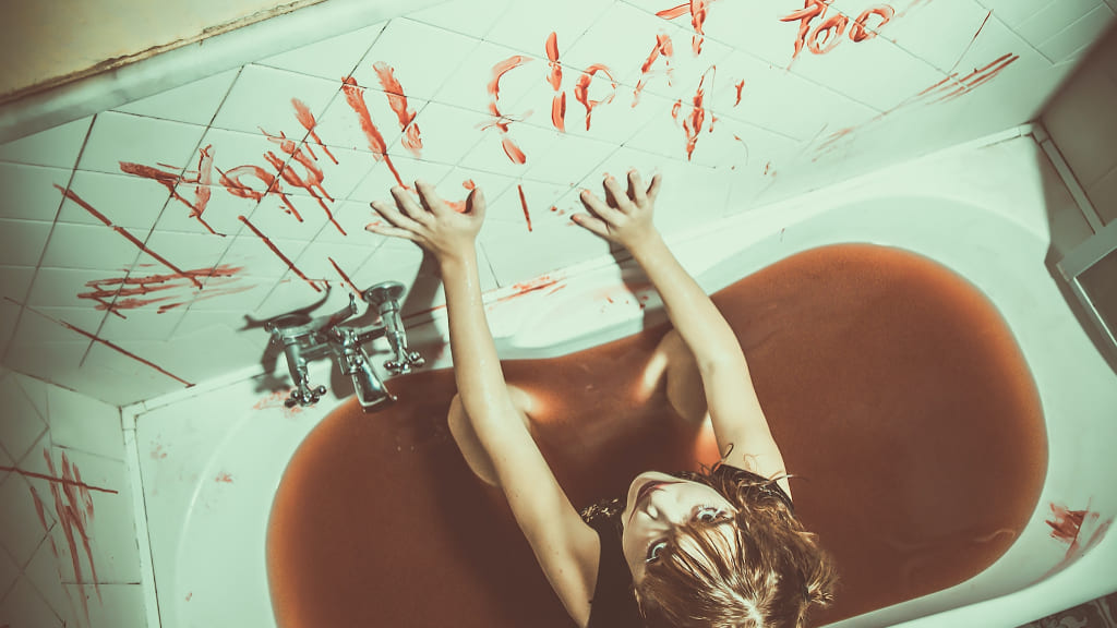 風呂場のタイルに血で文字を書く女性